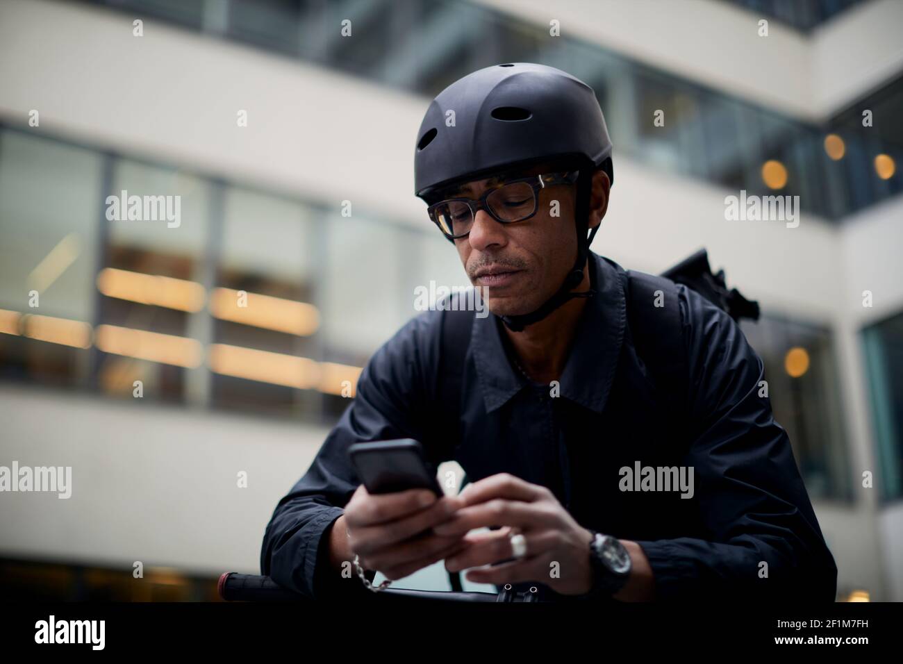 Bicycle courier using cell phone Stock Photo