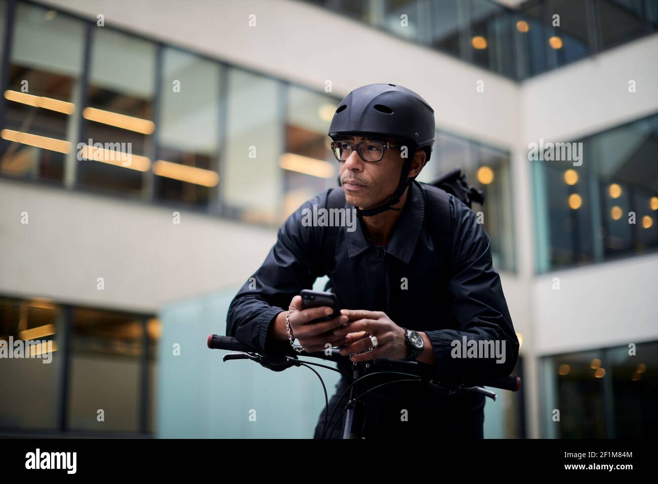 Bicycle courier using cell phone Stock Photo