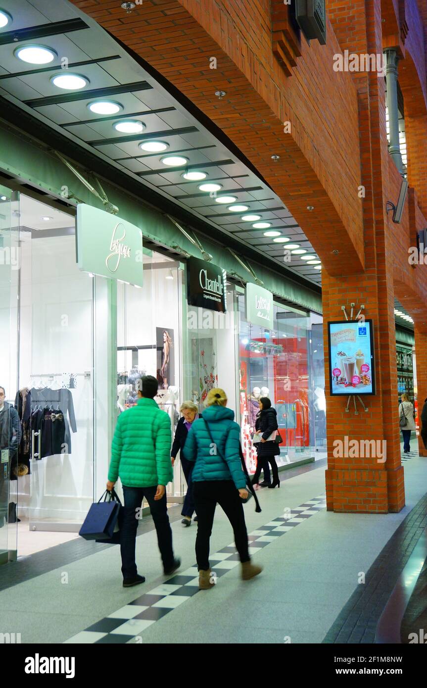 POZNAN, POLAND - Dec 01, 2013: People walking along shops in the Stary Browar shopping mall. Stock Photo