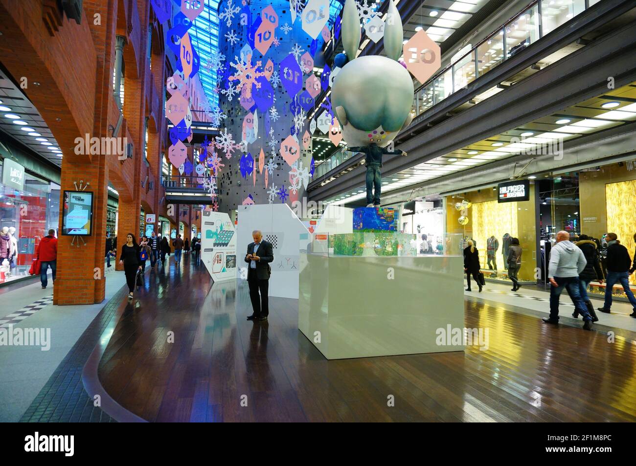 POZNAN, POLAND - Dec 01, 2013: Many shops and people with figurine in the Stary Browar shopping mall. Stock Photo