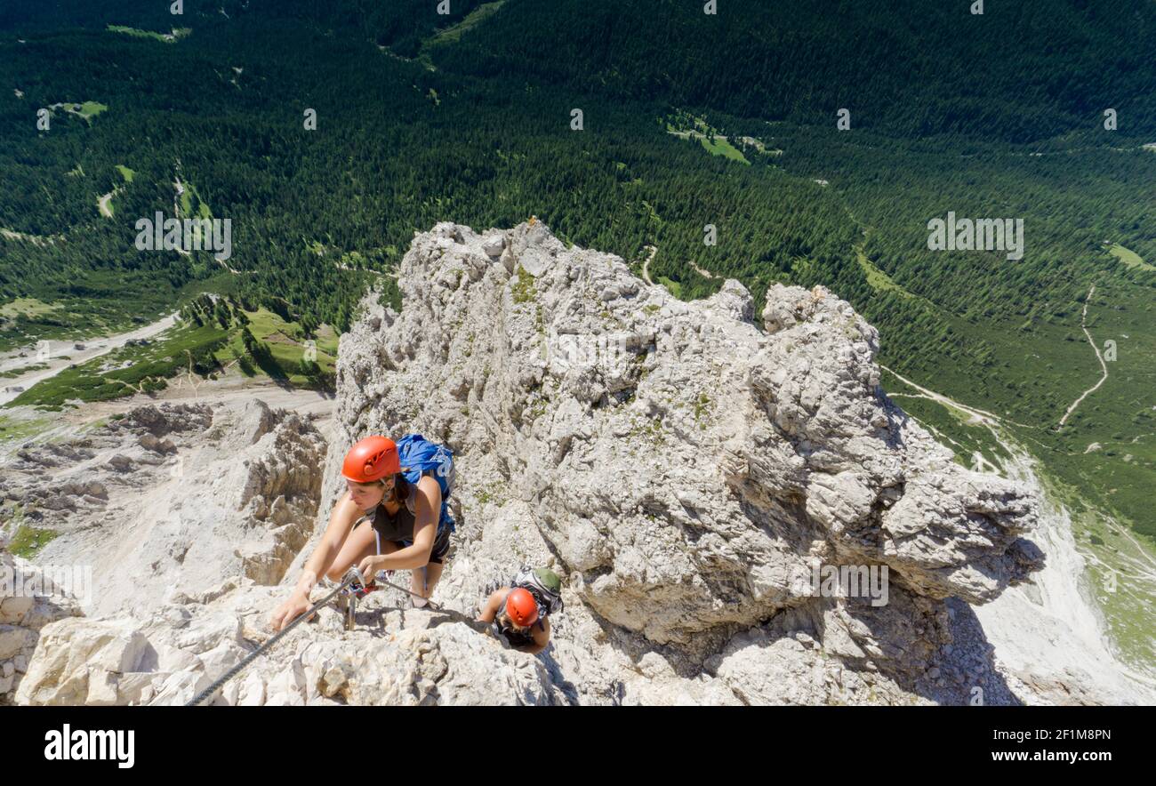 Two women mountain climbers on an exposed Via Ferrata in the Dolomites