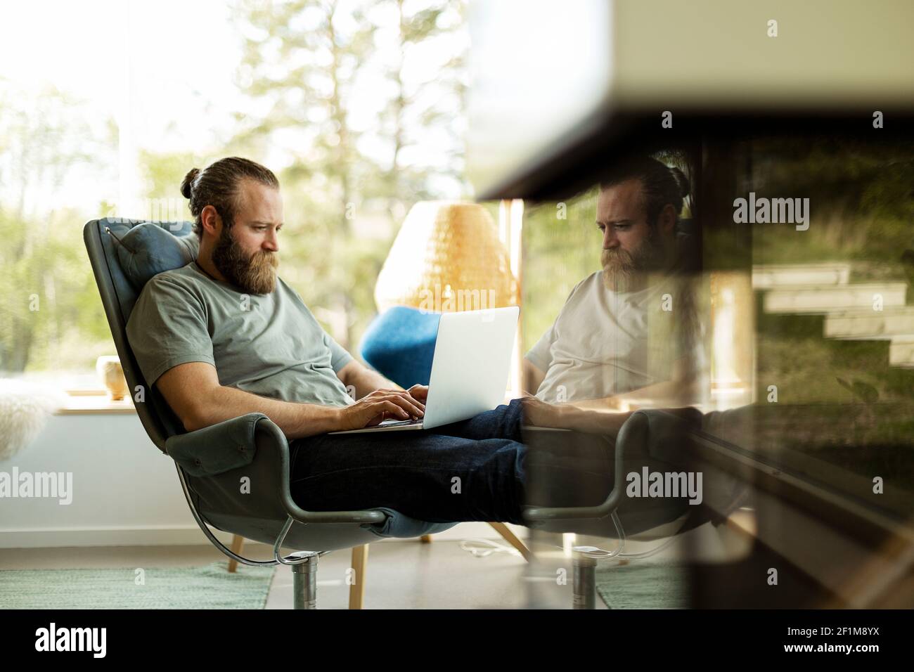 Man sitting on chair and using laptop Stock Photo