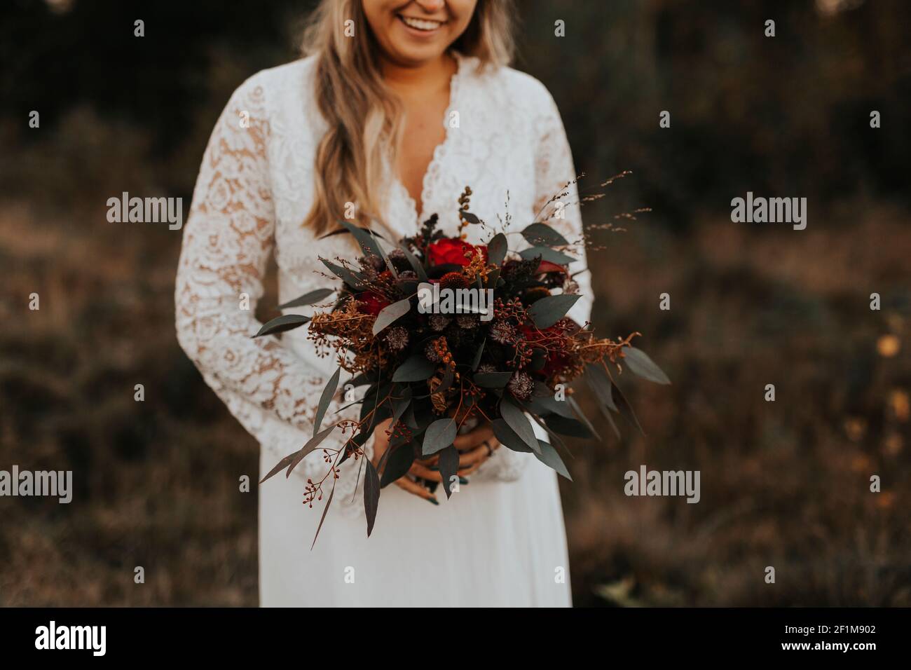 Mid section of bride holding wedding bouquet Stock Photo