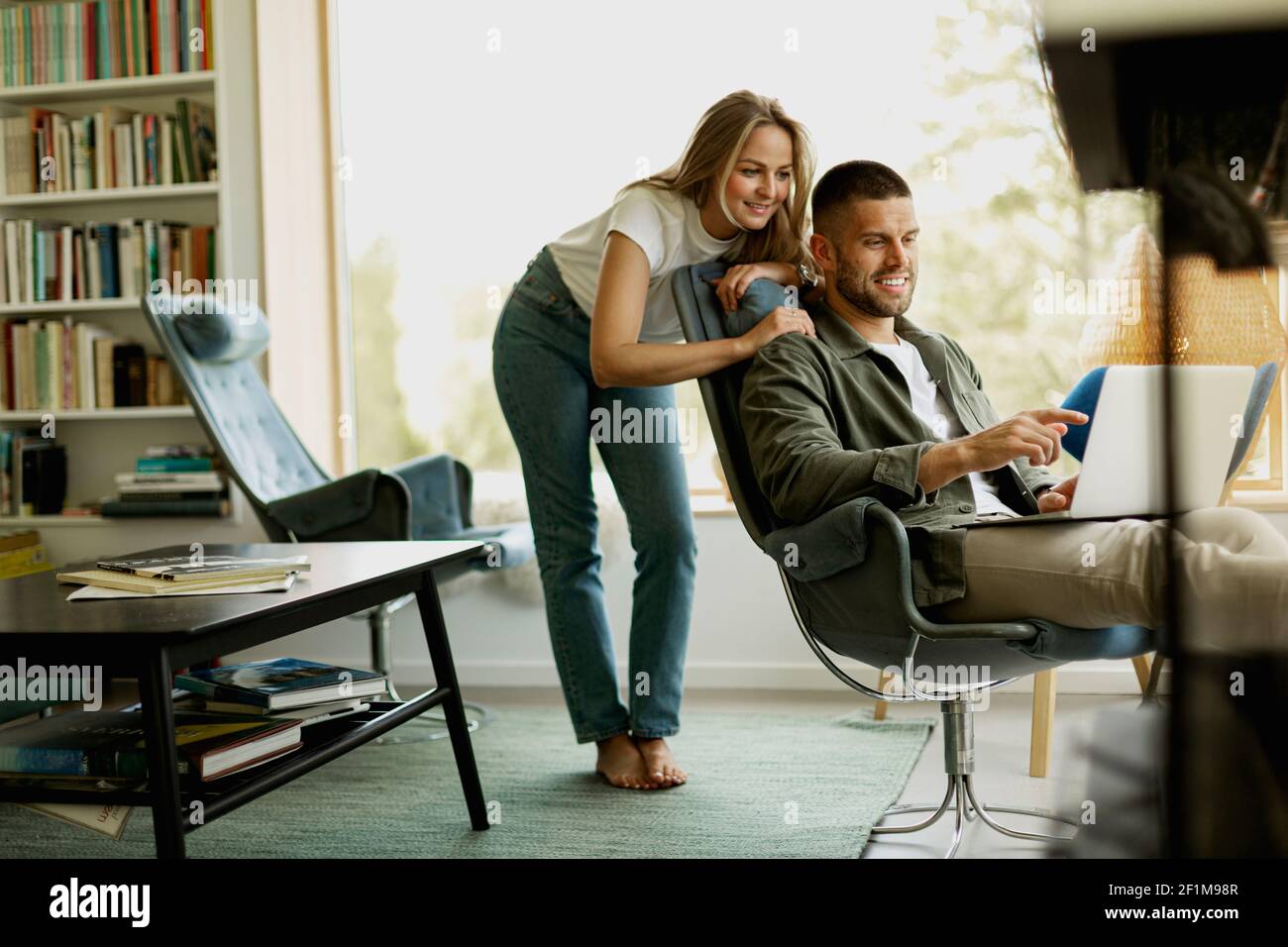 Couple using laptop in living room Stock Photo - Alamy