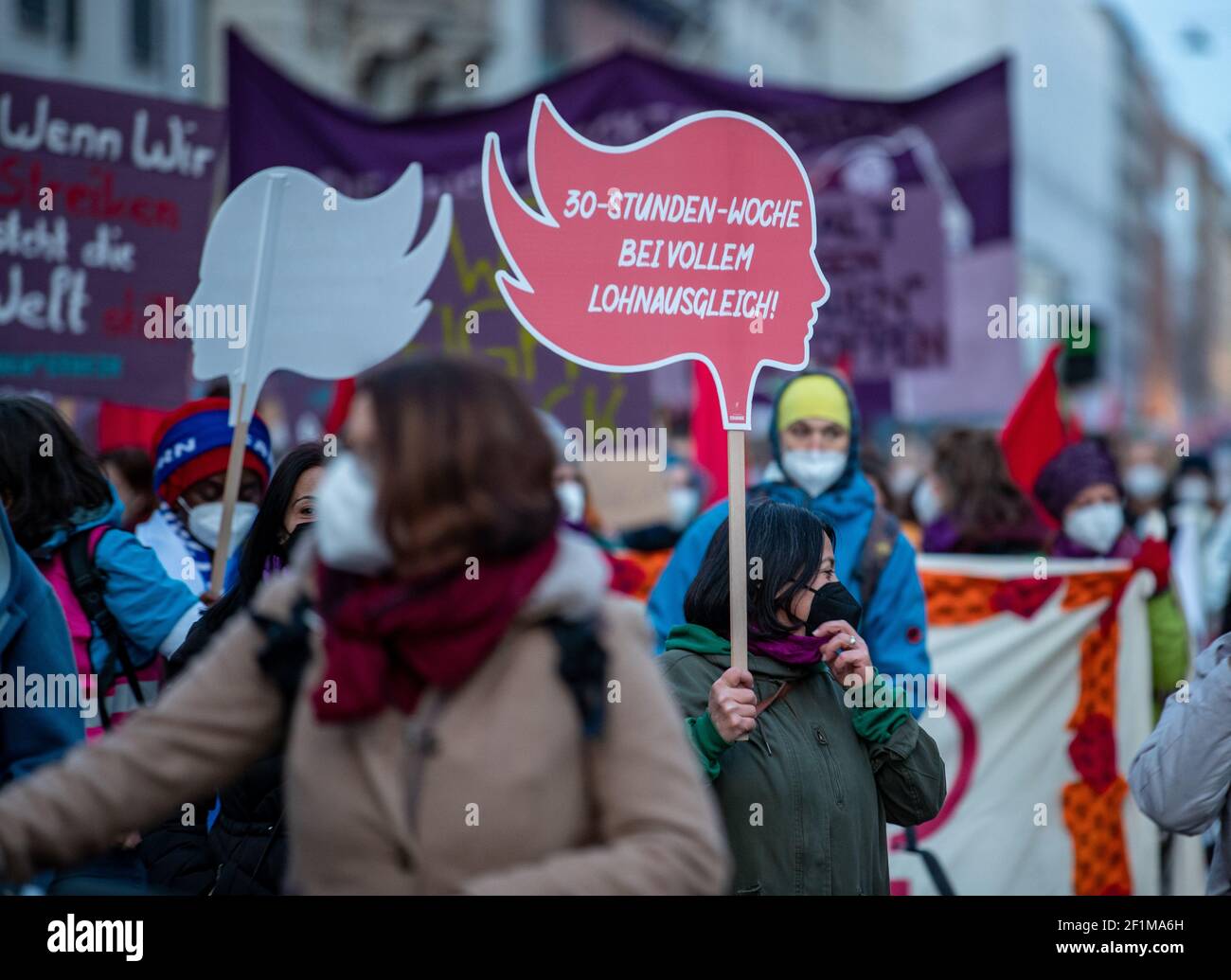 Demonstrantin hält Schild mit der Aufschrift: ' 30-Stunden-Woche bei vollem Lohnausgleich! ' Am Weltfrauentag, dem 8.3.2021 haben sich in München um die 1000 Menschen versammelt, um für das Recht auf Schwangerschaftsabbrüche, gegen den Gender-Pay-Gap, Sexismus und Femizide zu demonstrieren. - On the international women's day March 8 2021 around 1000 people joined a demonstration in Munich, Germany to protest against sexism, the gender-pay-gap and femicides. (Photo by Alexander Pohl/Sipa USA) Stock Photo