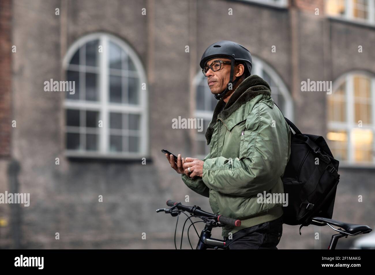 Bicycle courier using cell phone Stock Photo Alamy