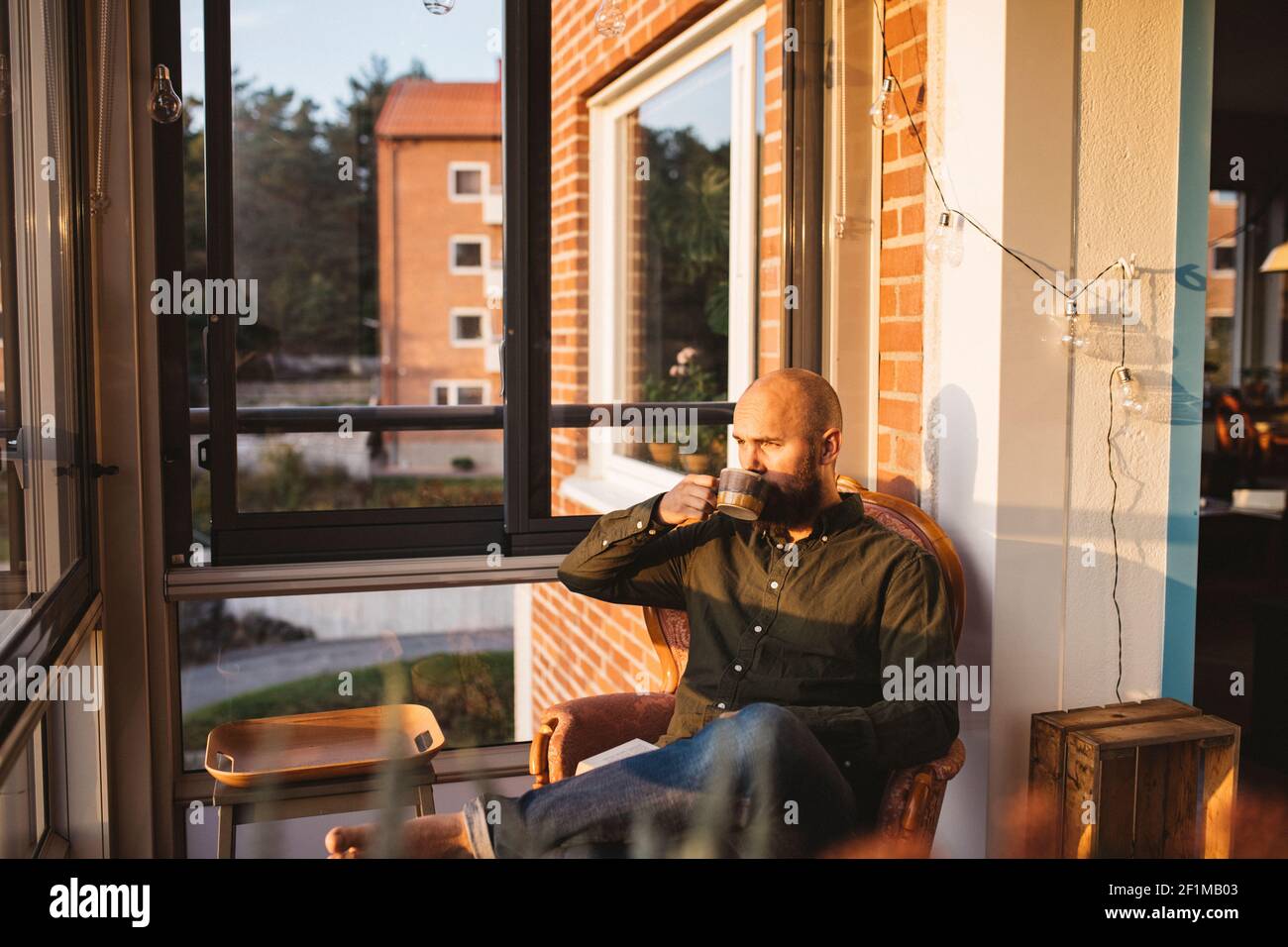 Man having coffee on balcony Stock Photo