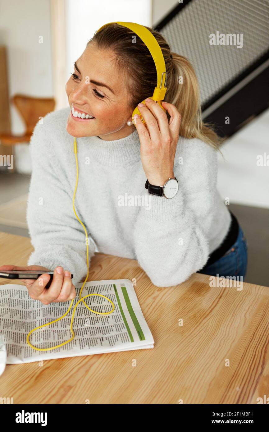 Blond woman listening music at home Stock Photo