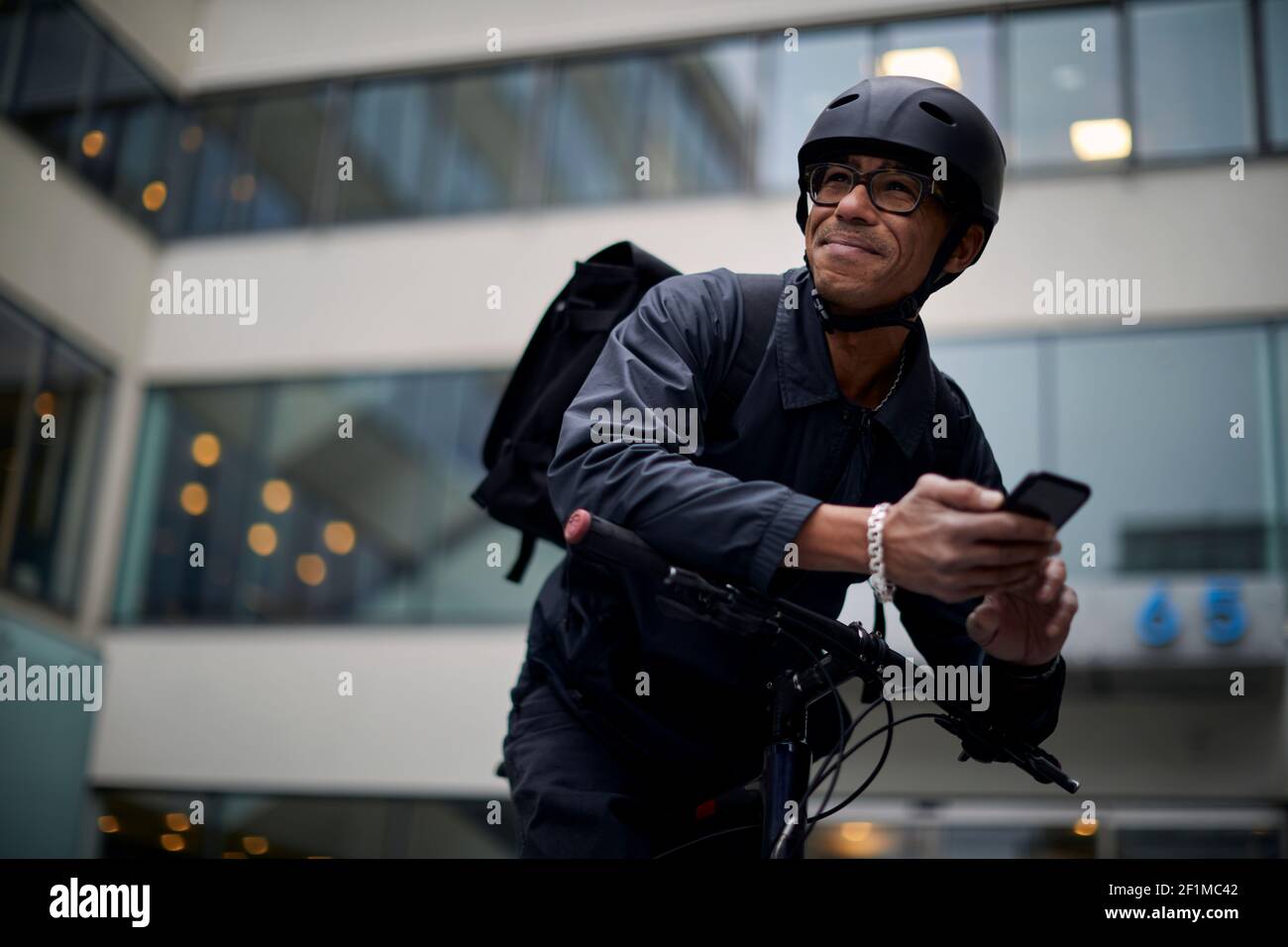 Bicycle courier using cell phone Stock Photo