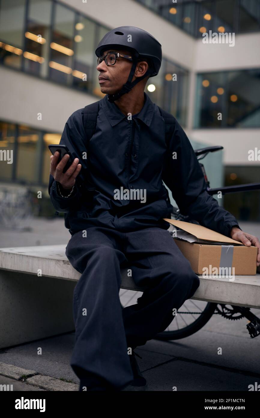 Bicycle courier using cell phone Stock Photo