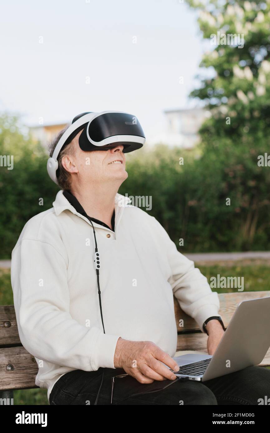 Man in park using VR headset Stock Photo