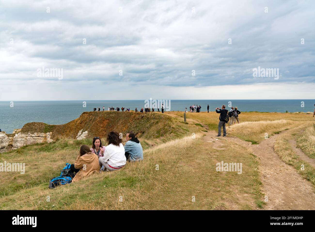 Tourists enjoy hiking and picknicking on the Normandy coast along the Falaise de Etretat cliffs abov Stock Photo