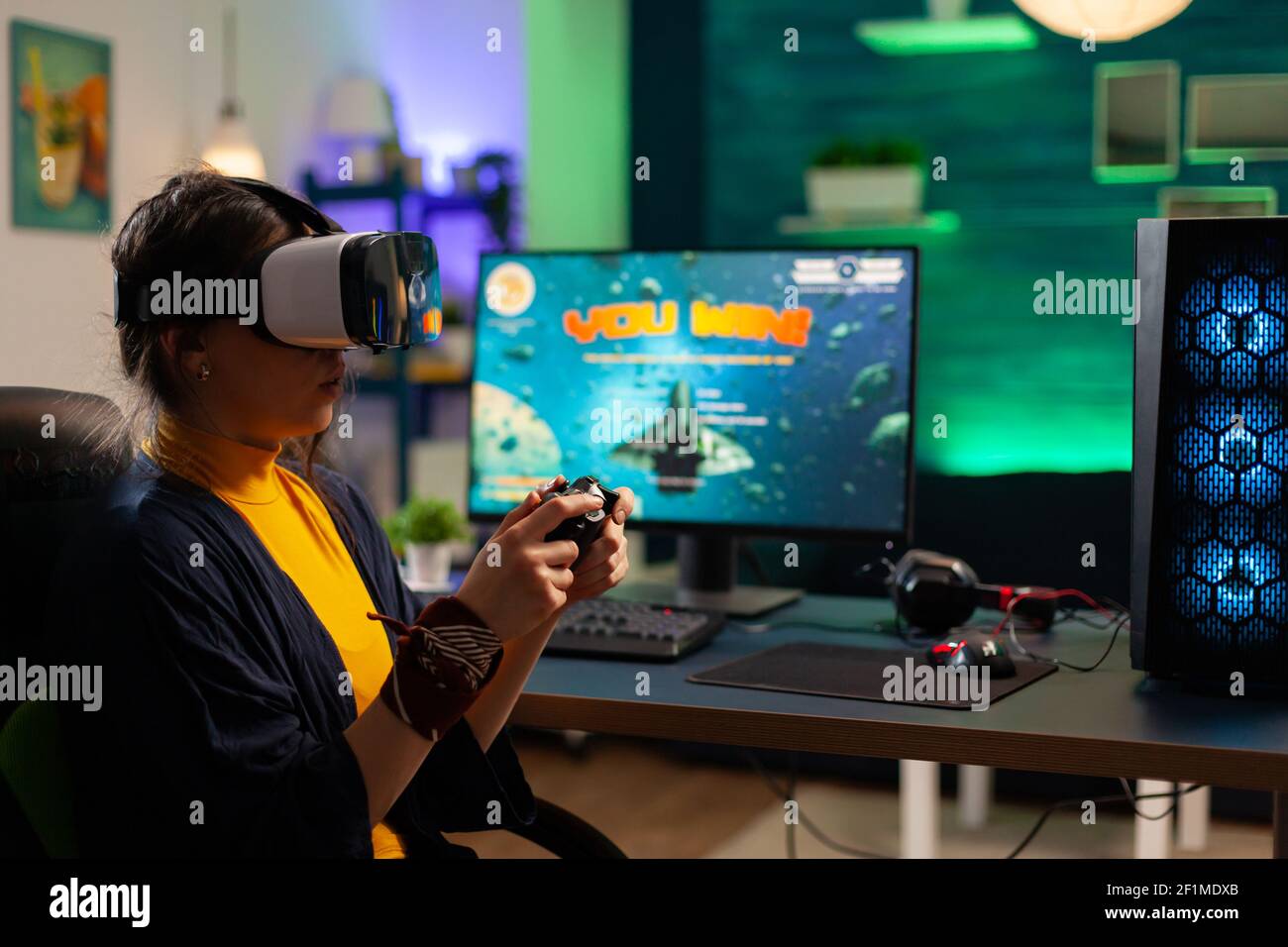 Competitive gamer looking into powerful computer playing online shooter game late at night with vr headset and console wireless