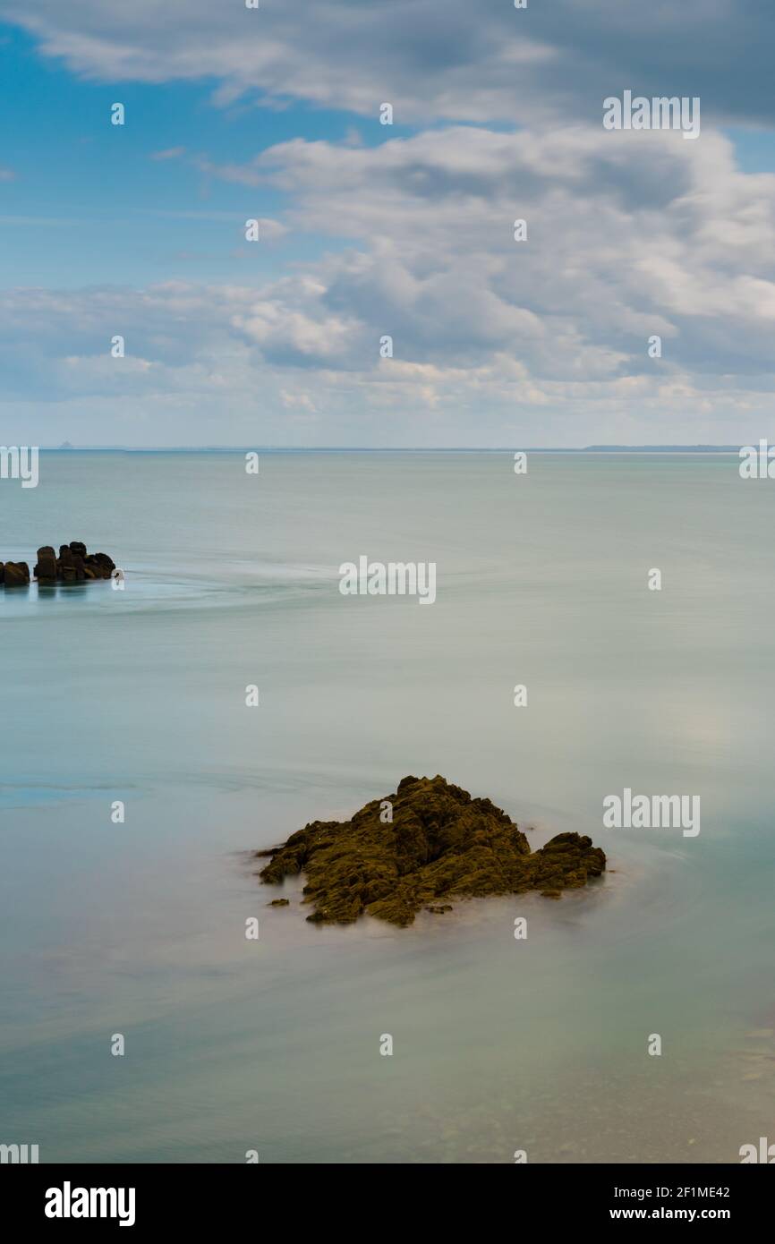 Rocky reef at low tide in a calm ocean on the coast of Normandy Stock Photo