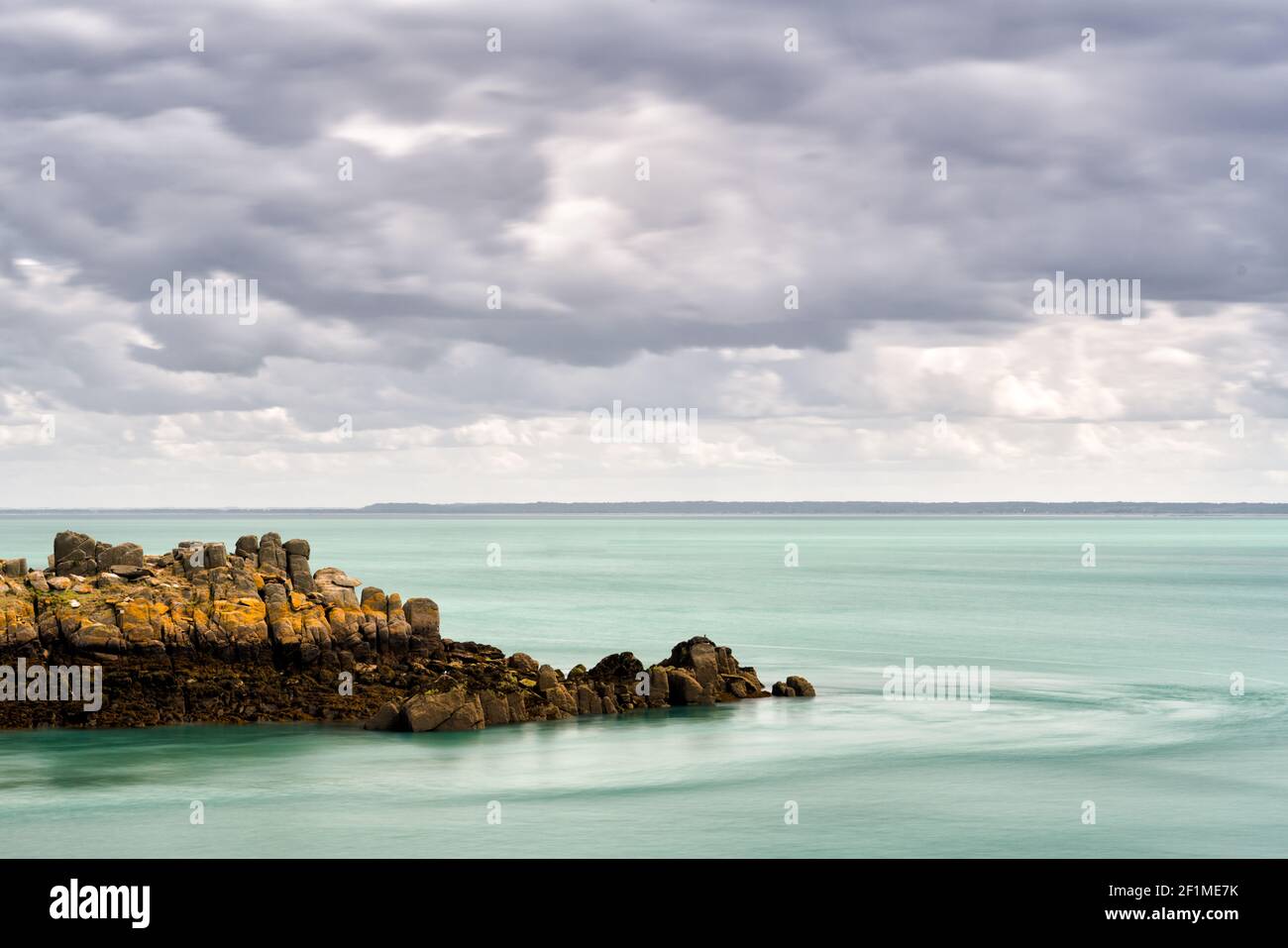 Rocky reef at low tide in a calm ocean on the coast of Normandy Stock Photo