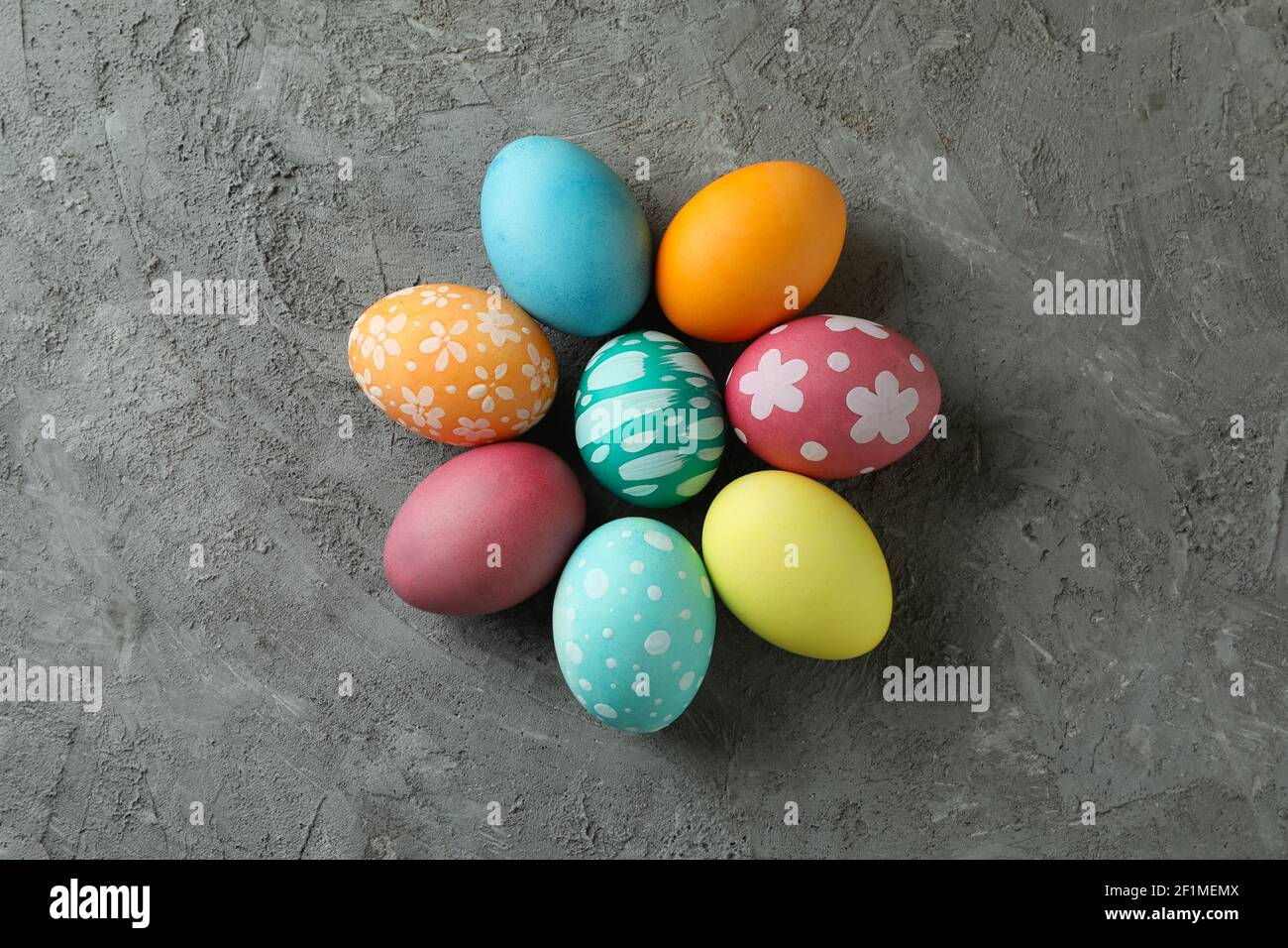 Beautiful multicolor Easter eggs with patterns on a gray concrete background, top view Stock Photo