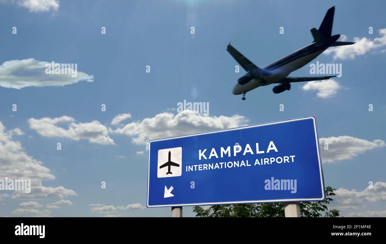 Airplane silhouette landing in Kampala, Uganda. City arrival with international airport direction signboard and blue sky in background. Travel, trip a Stock Photo