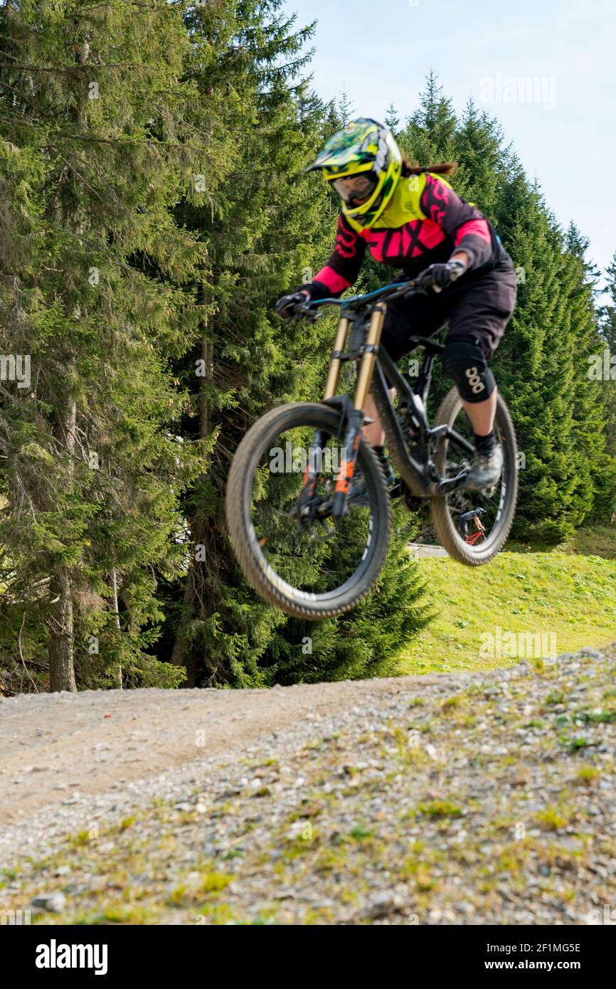 Downhill mountain biker jumping high and riding hard in Lenzerheide in the Swiss Alps Stock Photo