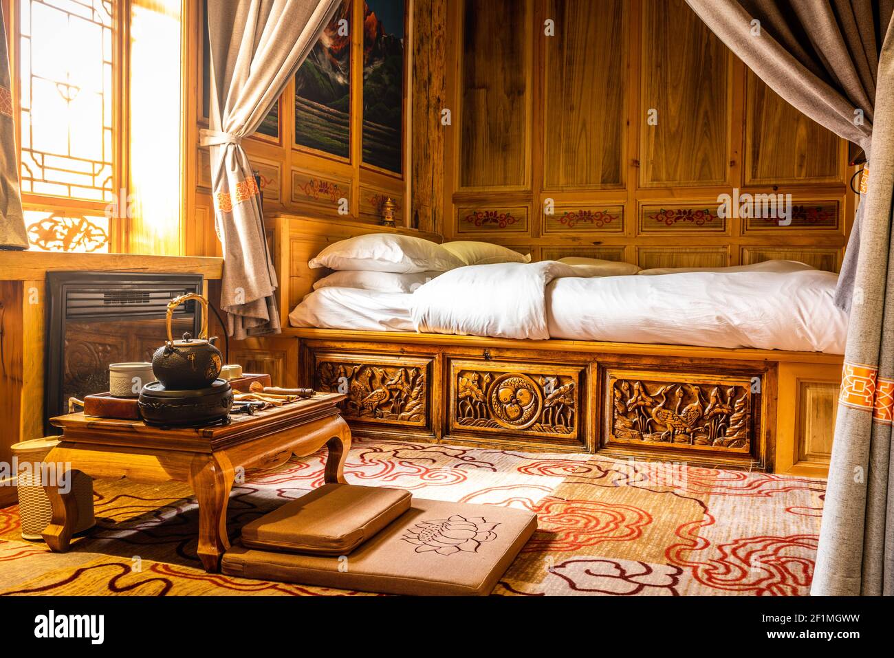 Shangri-La China , 8 October 2020 : Typical Tibetan bedroom with tea table and bed with warm colours and dramatic light in Tibet China Stock Photo
