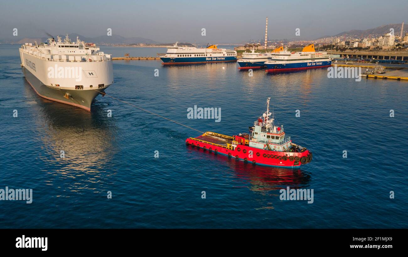 A big tanker being dragged in Piraeus port ,Greece Stock Photo - Alamy