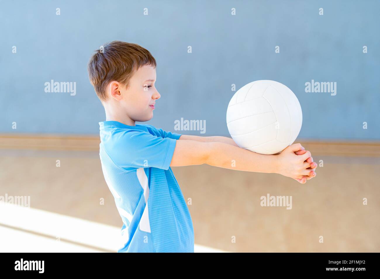 School kid playing volleyball in a physical education lesson. Safe back