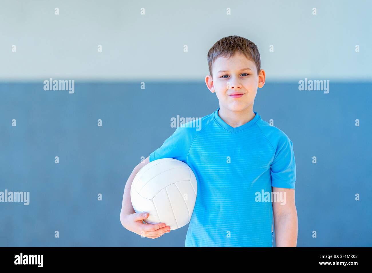 School kid playing volleyball in a physical education lesson. Safe back