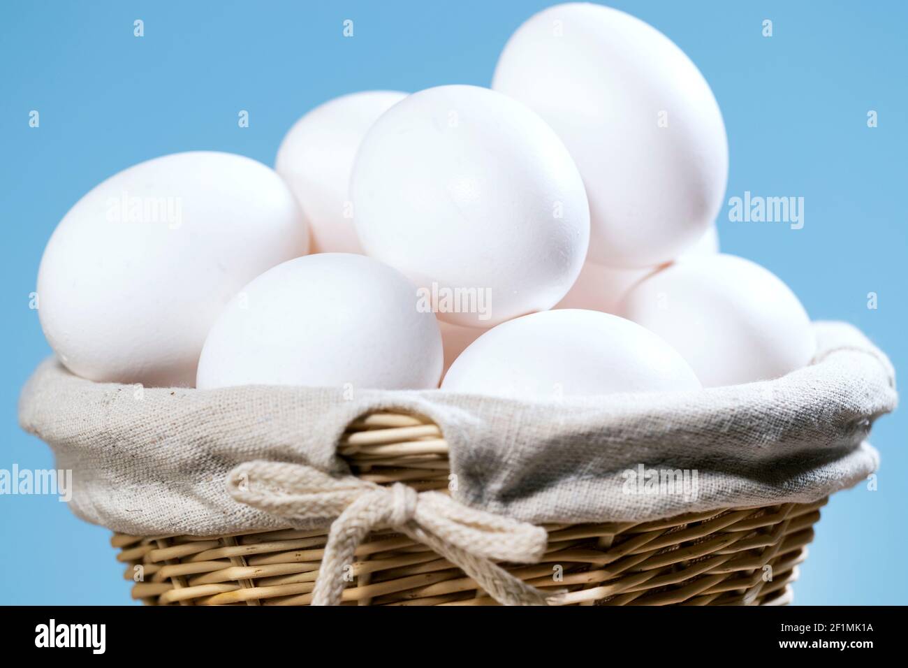 Chicken Eggs in a straw Basket, A lot of White Fresh Raw eggs in a container, Natural Eko Product, Easter preparing Copyspace Stock Photo