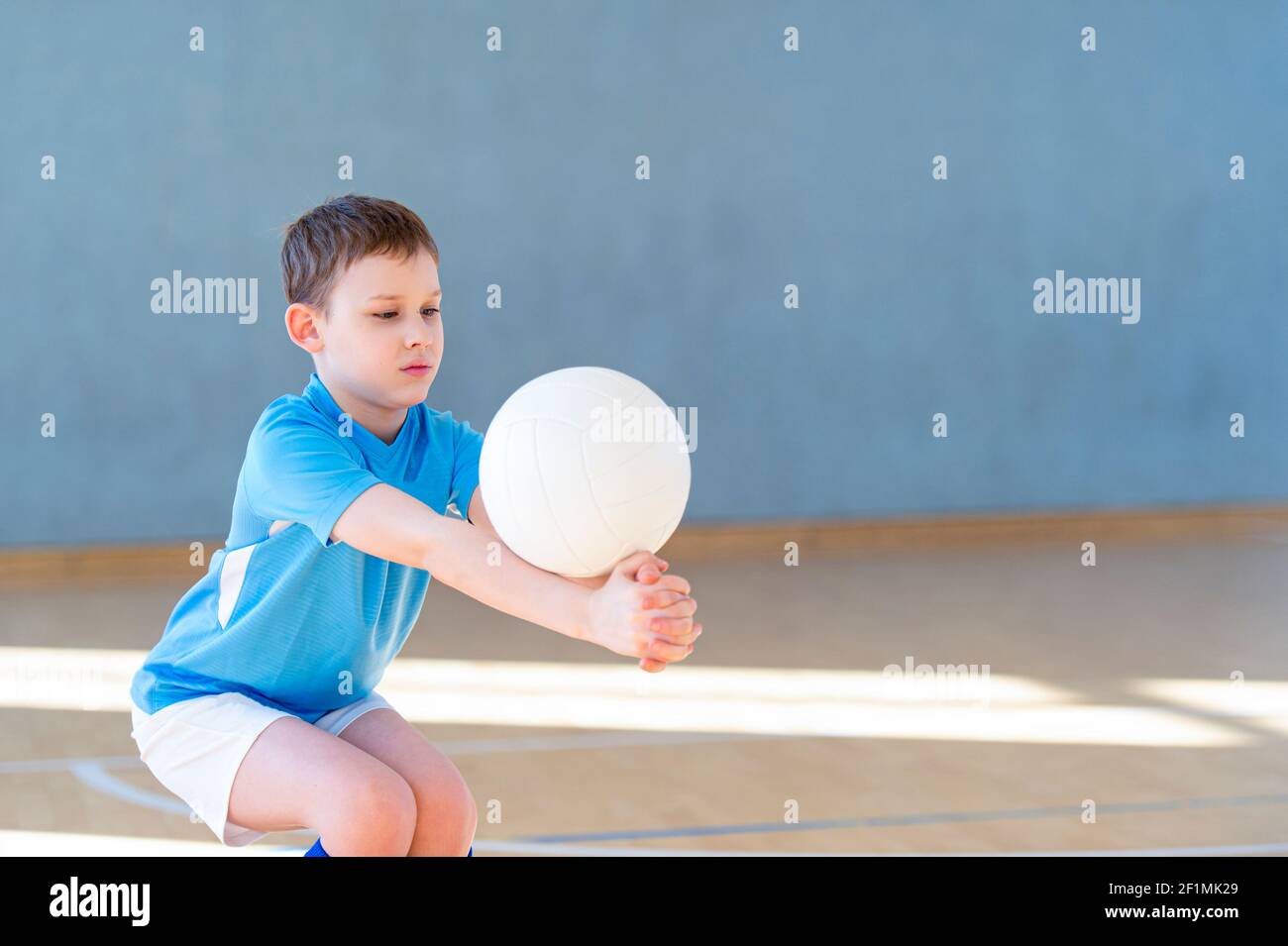 School kid playing volleyball in a physical education lesson. Safe back to school during pandemic concept Stock Photo