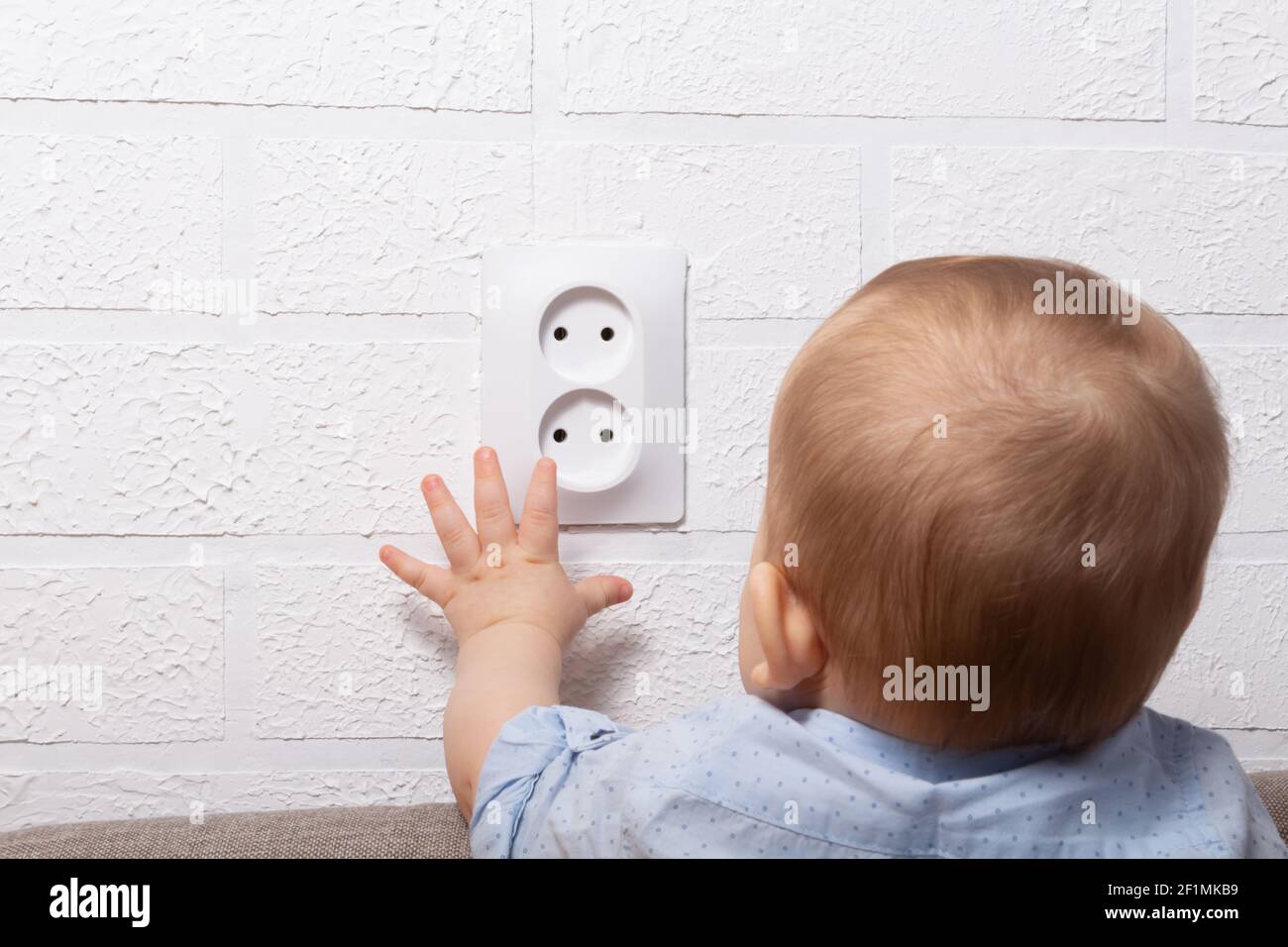 Unrecognizable caucasian boy is playing with open electrical outlet