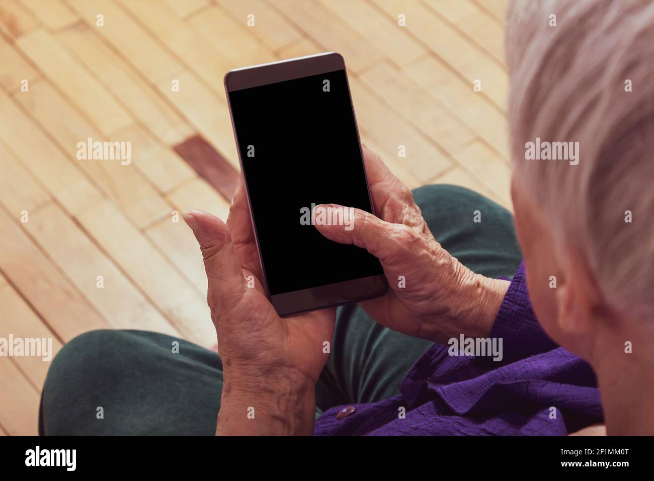 Very old woman holding cell phone. Close-up. Top view Stock Photo - Alamy
