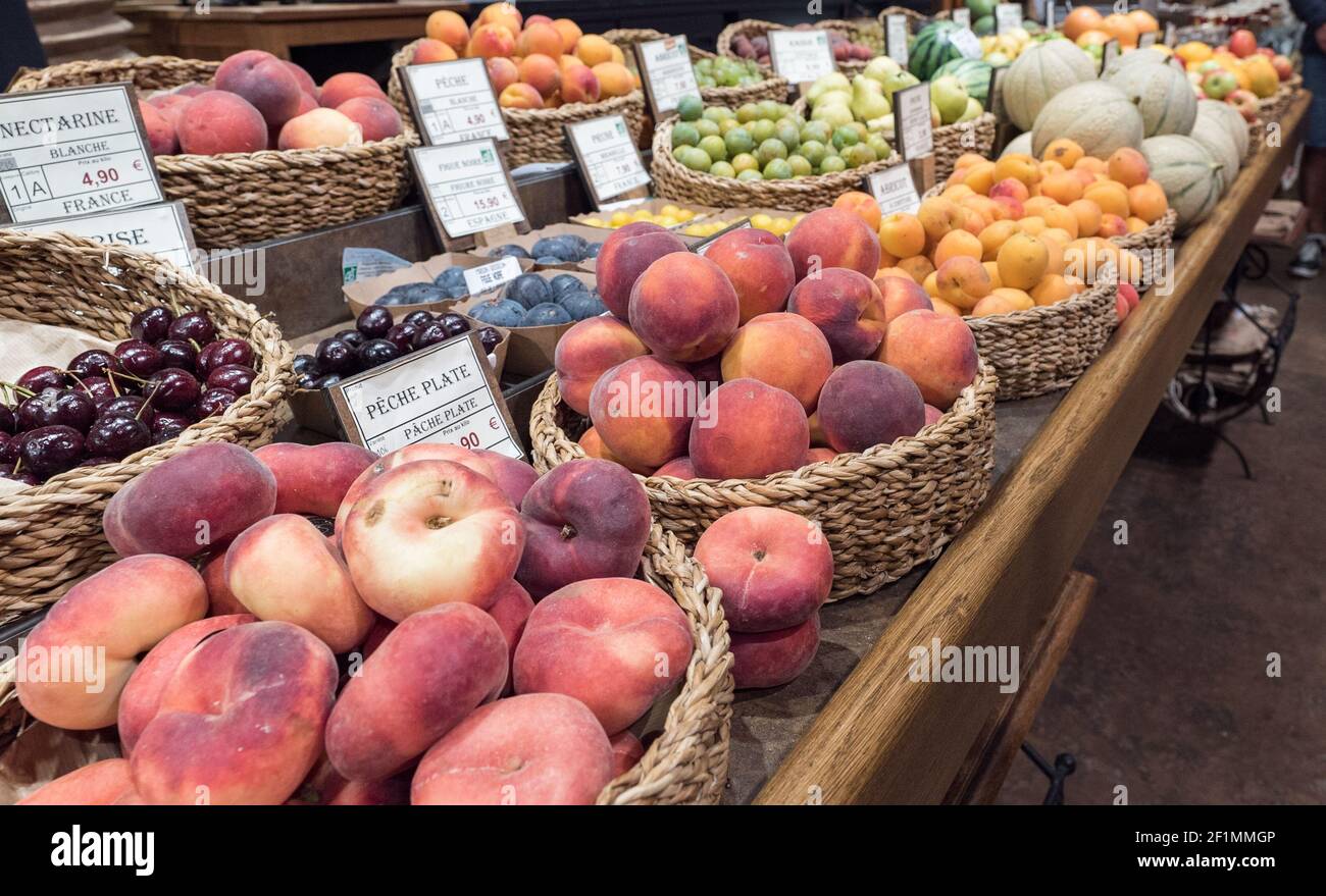 Market stand with many different fruit and labels with names and prices