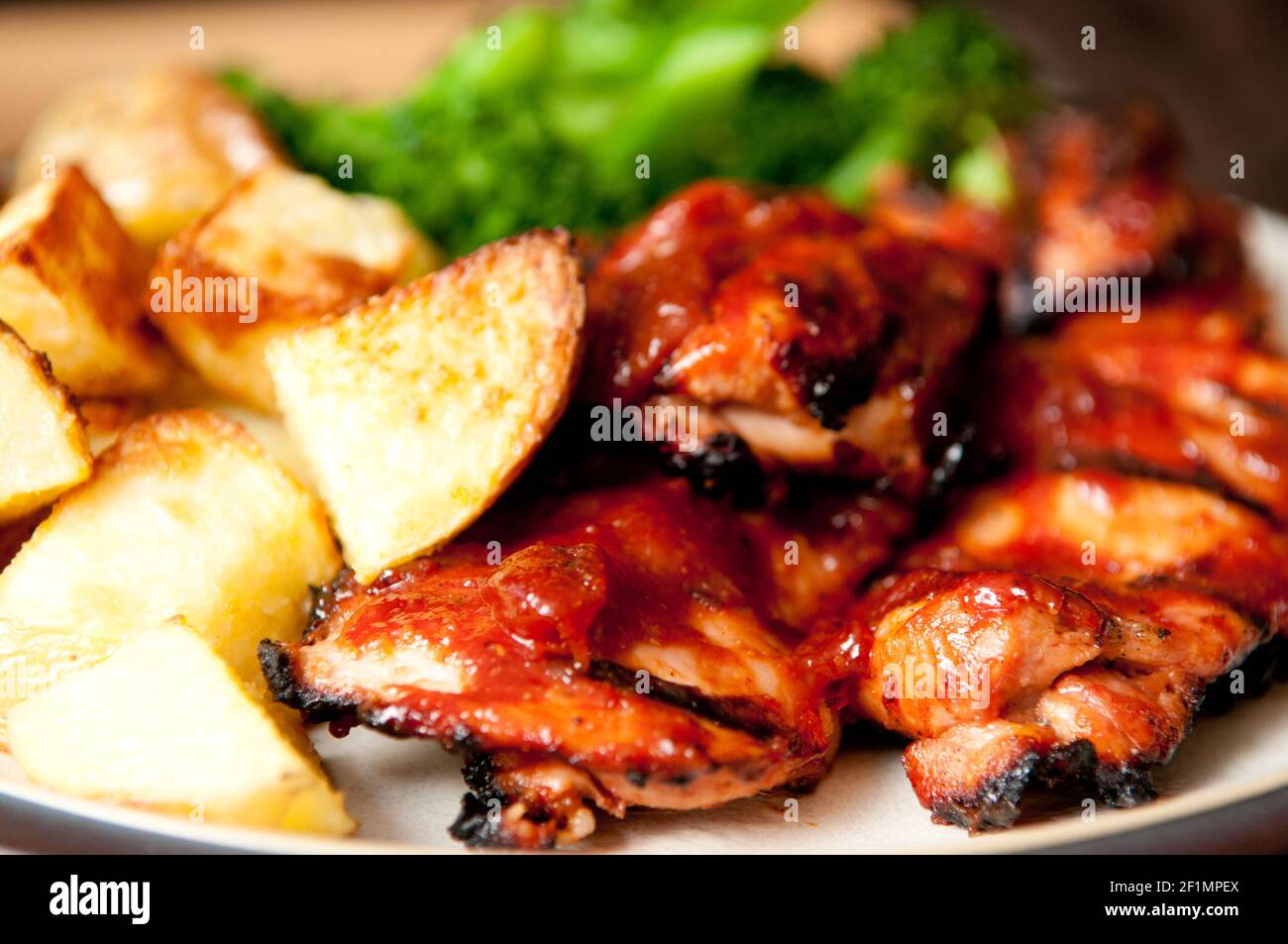crispy chicken thighs with fingerling potatoes, carrots and green vegetables Stock Photo Alamy