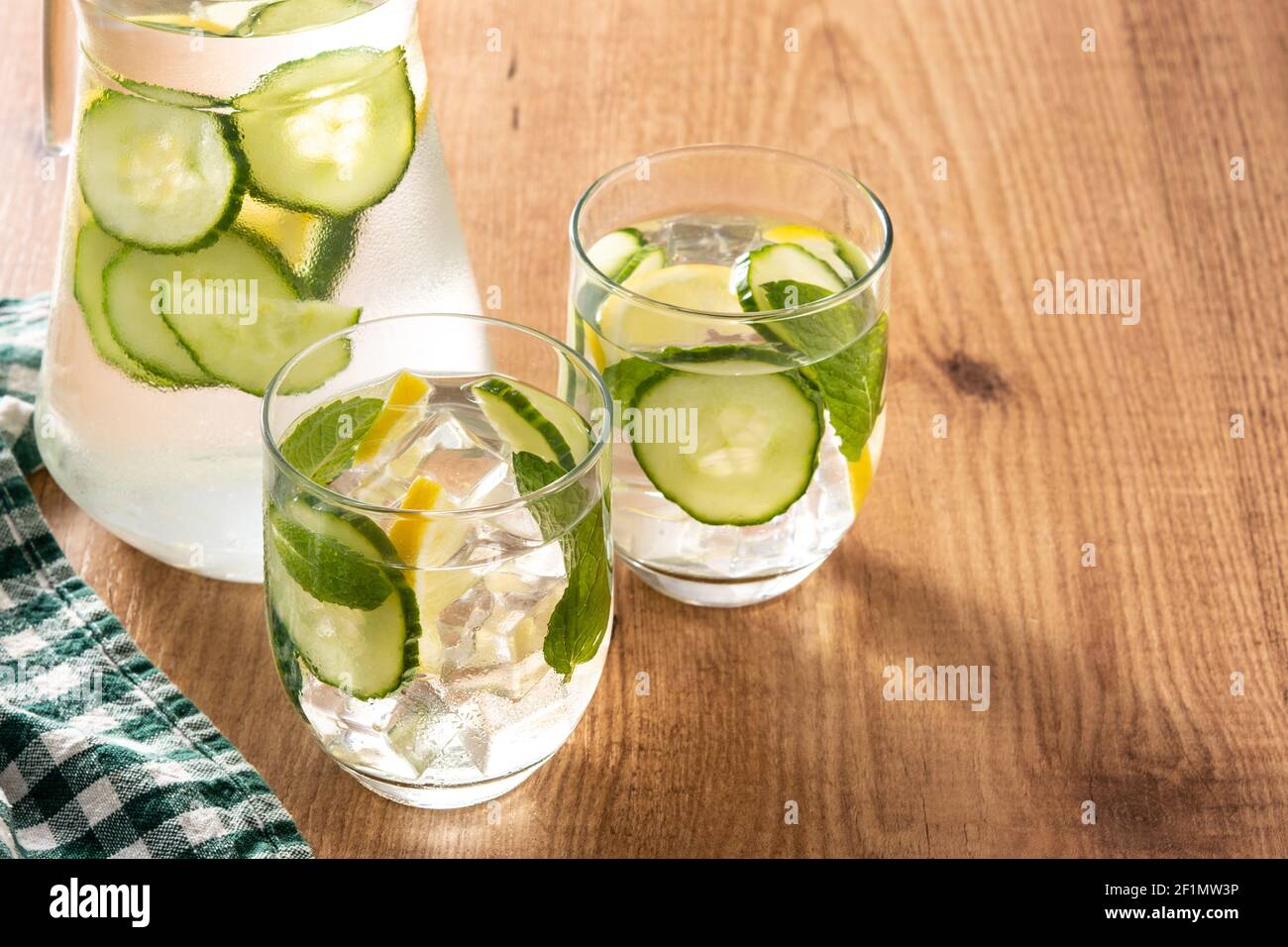 Sassy water or water with cucumber and lemon on wooden table Stock Photo