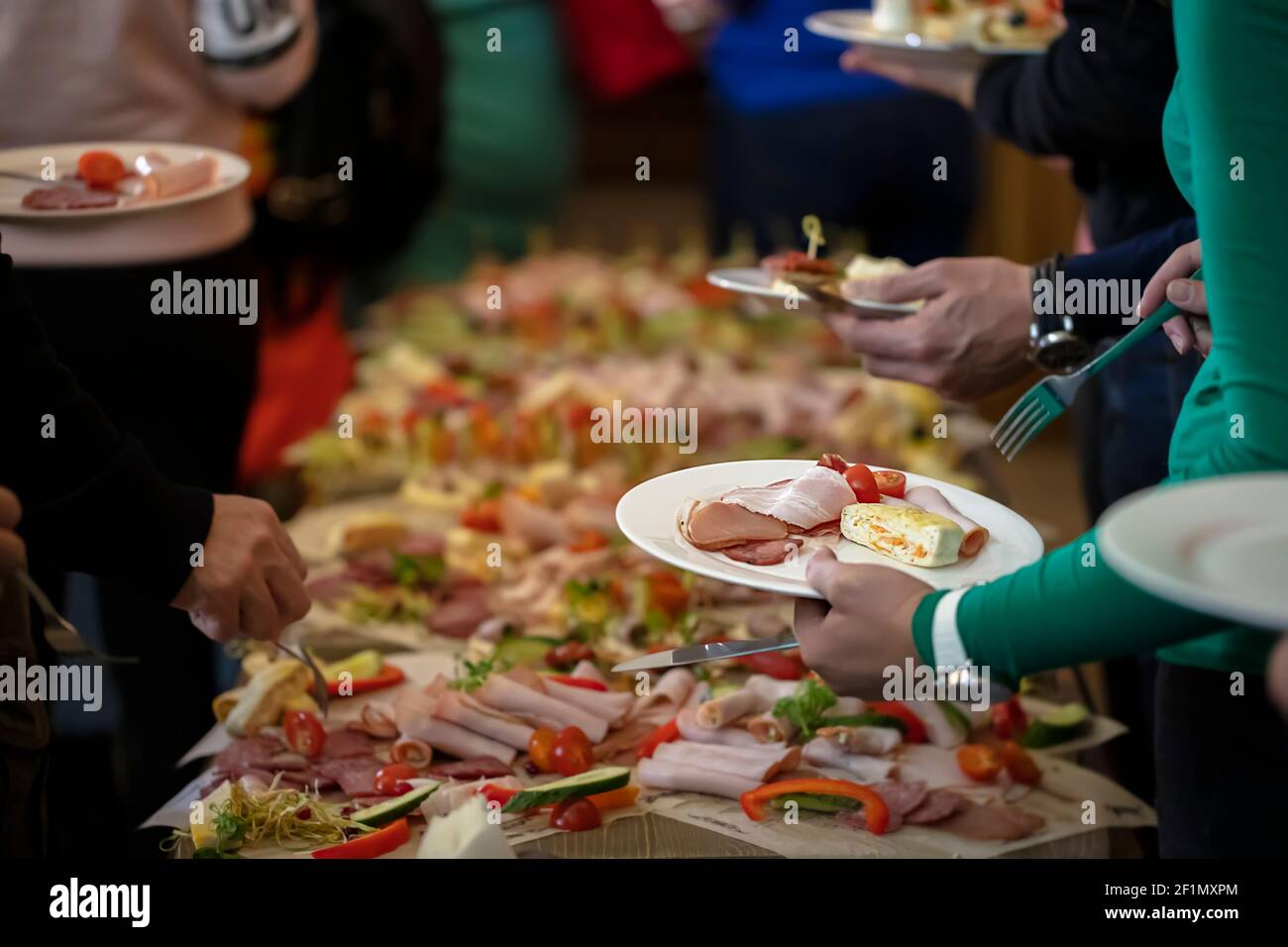 Buffet. Hands with a plate on the background of a table with food Stock