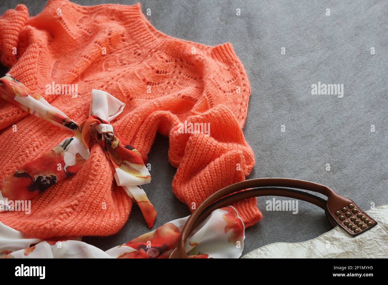 Flat Lay Shot Of Female Spring Clothing And Accessories. Pink Sweater, Ddress, Handbag On Grey Backgound . Stock Photo