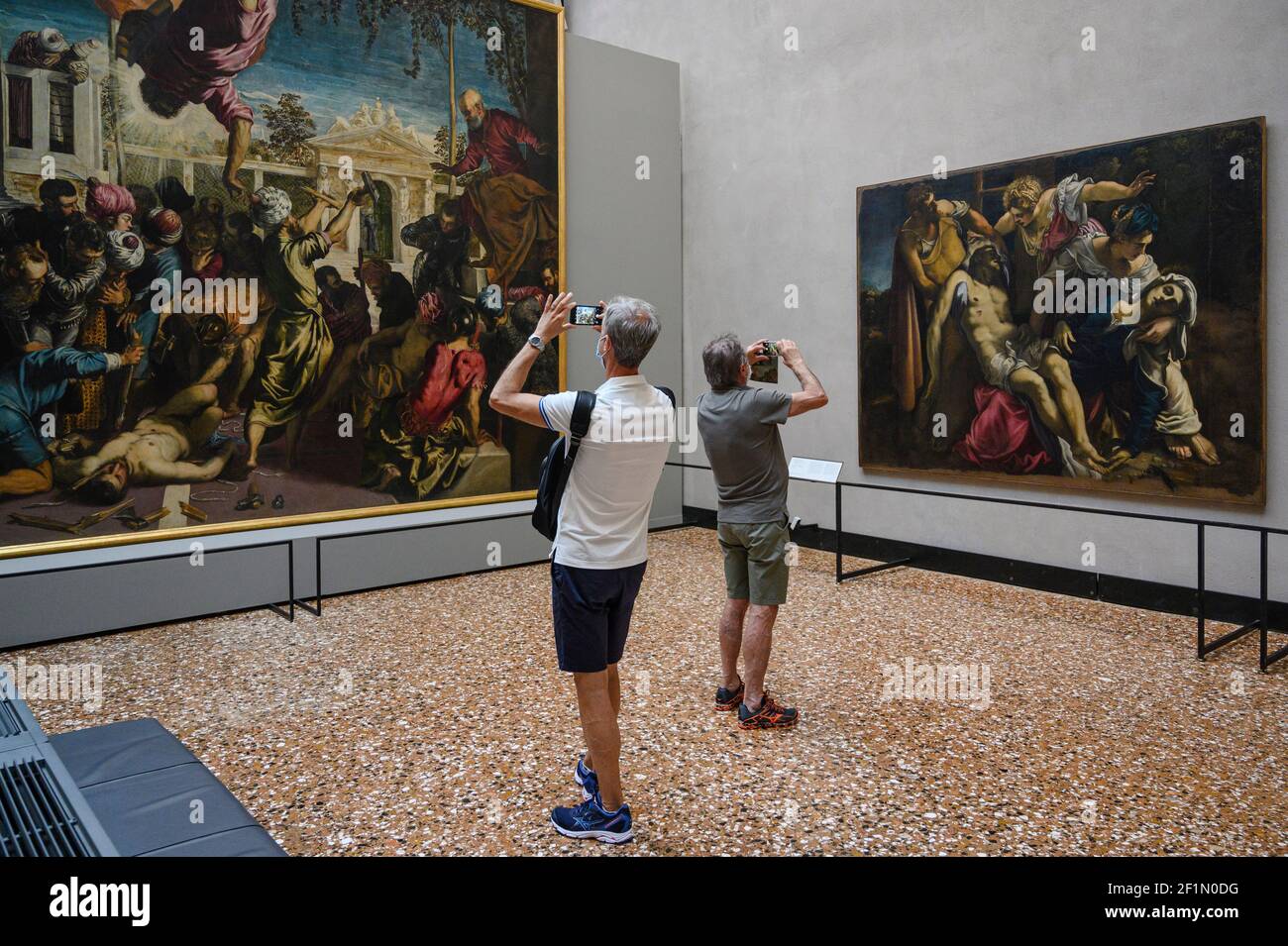 Venice. Italy. Accademia Gallery (Gallerie dell'Accademia), visitors to the gallery admiring the work of Tintoretto.  Paintings by Jacopo Tintoretto ( Stock Photo