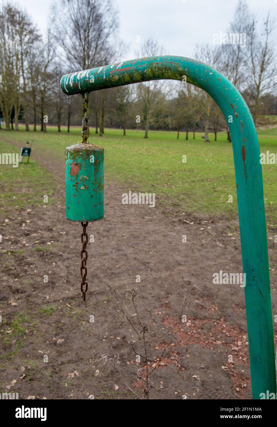 Green warning bell hanging from a metal support at the point where a