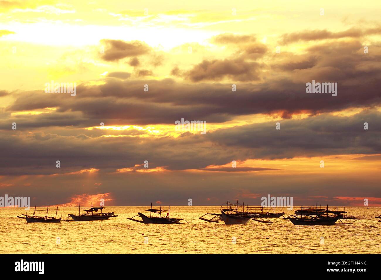 Floating Fishing Boat on A Cloudy Sunset Stock Photo