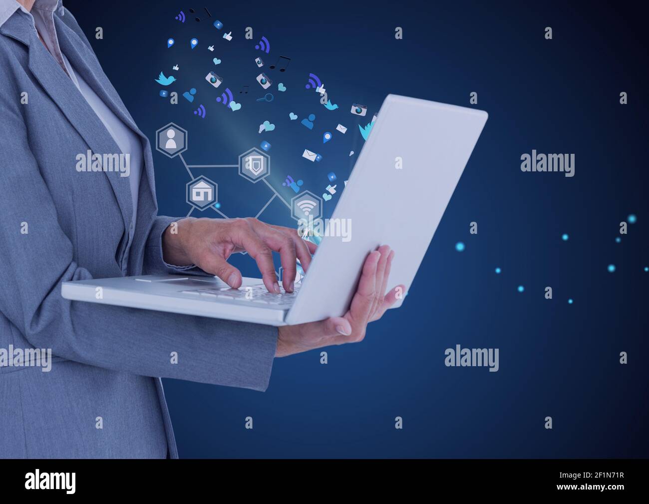 Network of digital icons over mid section of businesswoman using laptop ...
