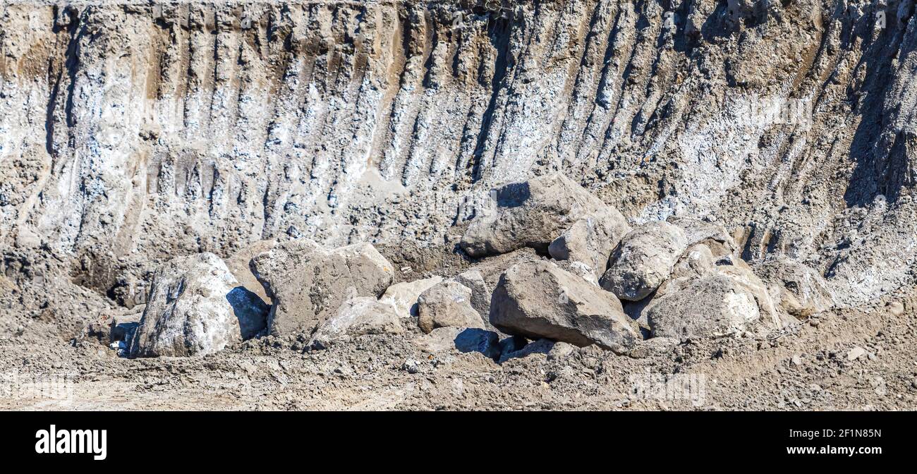 Digger Digging Rocks A digger has dug out rocks from different layers of soil, with an ...