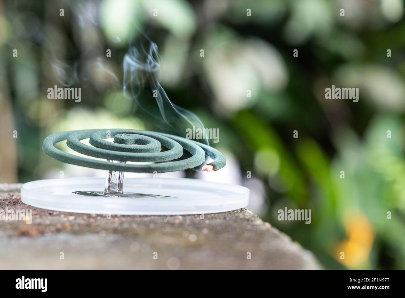 Closeup on traditional mosquito repellent coil emit smoke to repel mosquito outdoor Stock Photo