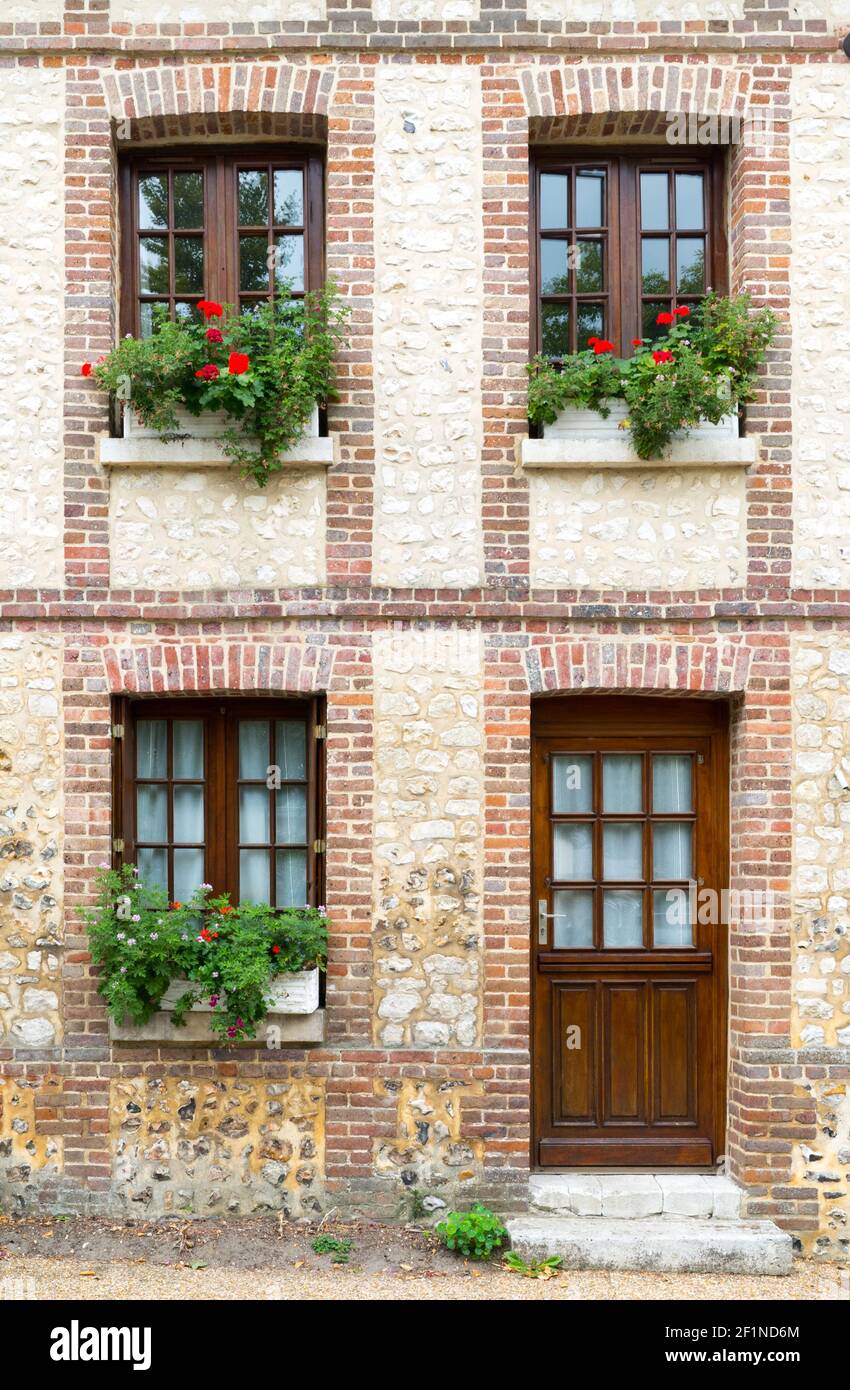 Typical Normandy architecture house front with stone and brick facade and  colorful flowerpots Stock Photo - Alamy