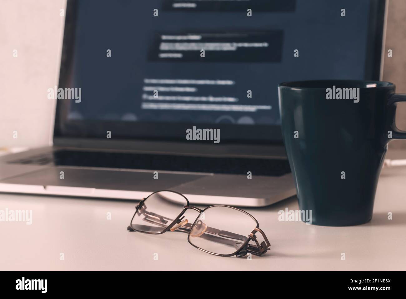 Glasses on the table next to the laptop. Remote work at the computer leads to fatigue and visual impairment. High quality photo Stock Photo