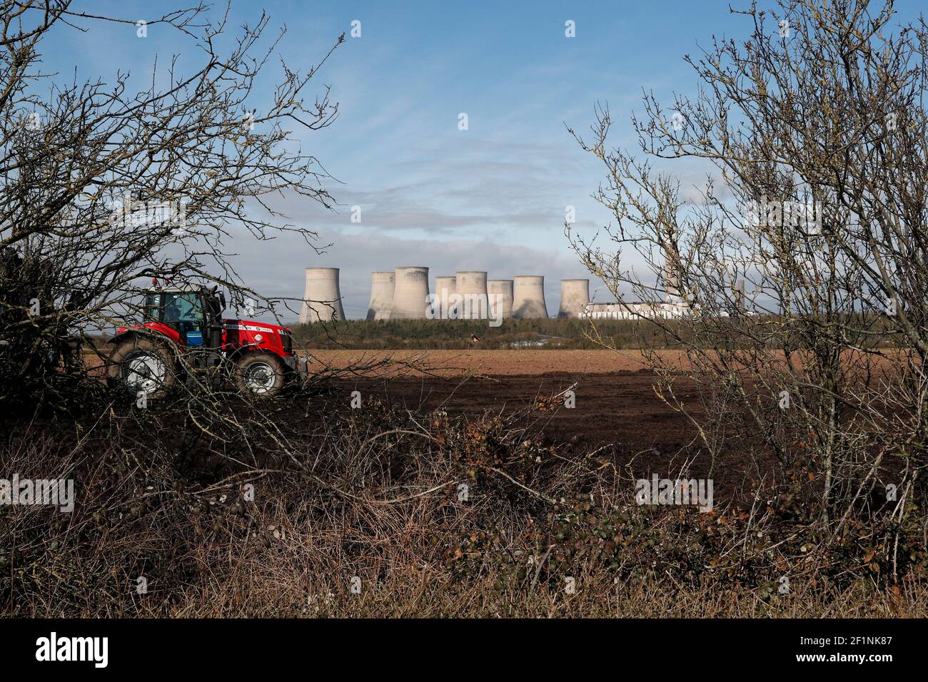 Ratcliffe-on-Soar, Nottinghamshire, UK. 9th March 2021. A farmer works near Ratcliffe-on-Soar Power Station as Rushcliffe Borough Council is to discuss an expression of interest for UniperÕs coal-powered Power Station site to accommodate a nuclear fusion reactor when it is decommissioned in 2025. Credit Darren Staples/Alamy Live News. Stock Photo