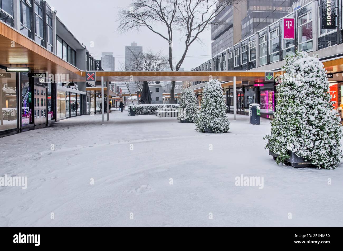 Rotterdam, The Netherlands, February 7, 2021: Lijnbaan pedestrian shopping street, almost deserted and snow-covered, on a cold winter day Stock Photo