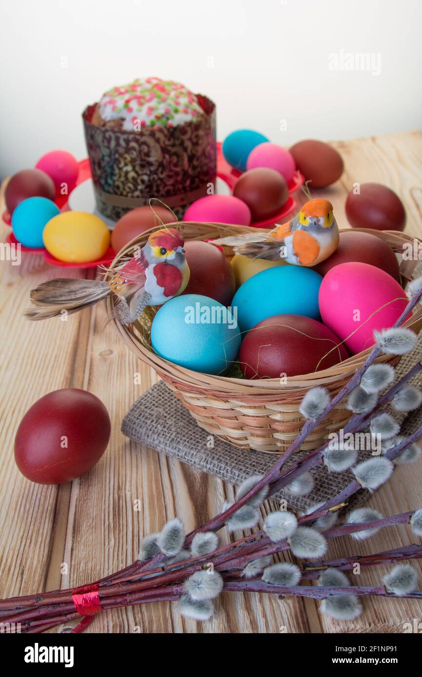 On the wooden table are two plates of Easter cake and painted eggs . Stock Photo