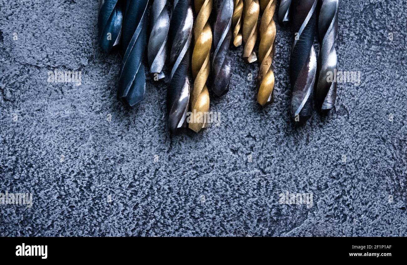 Different sizes drill bits on grey background with copy space Stock Photo
