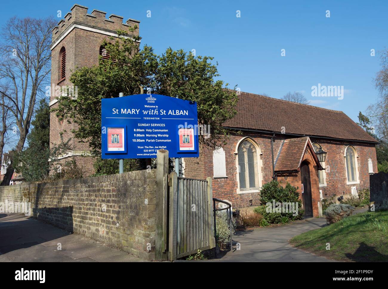 exterior of the partly 17th century church of saint mary with saint alban, teddington, middlesex, england, with welcome sign and sunday service times Stock Photo