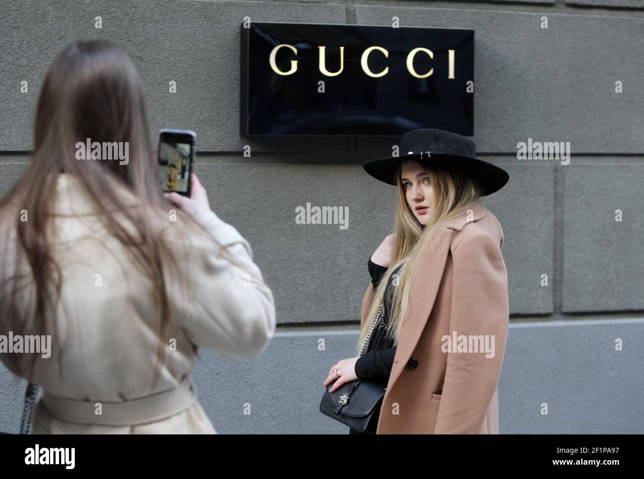 Kiev, Ukraine. 6th Mar, 2021. A young woman poses for a photo in front of  Gucci logo, of a luxury fashion house, outside a Gucci brand store. Credit:  Pavlo Gonchar/SOPA Images/ZUMA Wire/Alamy