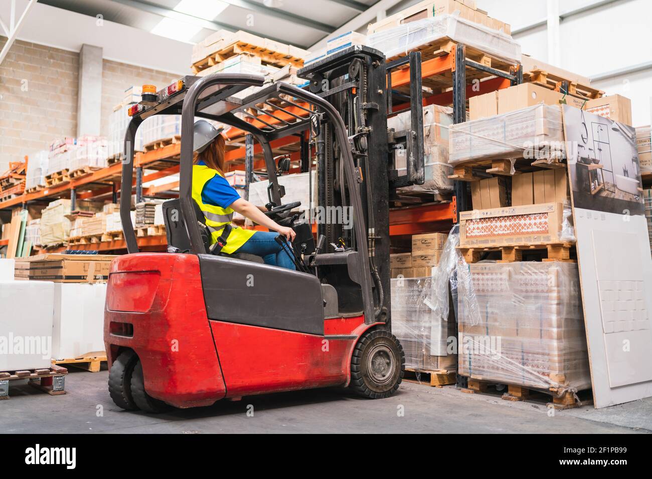 A Spanish woman worker using a forklift in a warehouse Stock Photo Alamy